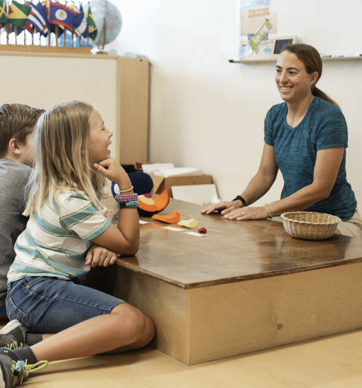 Teacher interacts and challenges two students learning about the earth's layers.