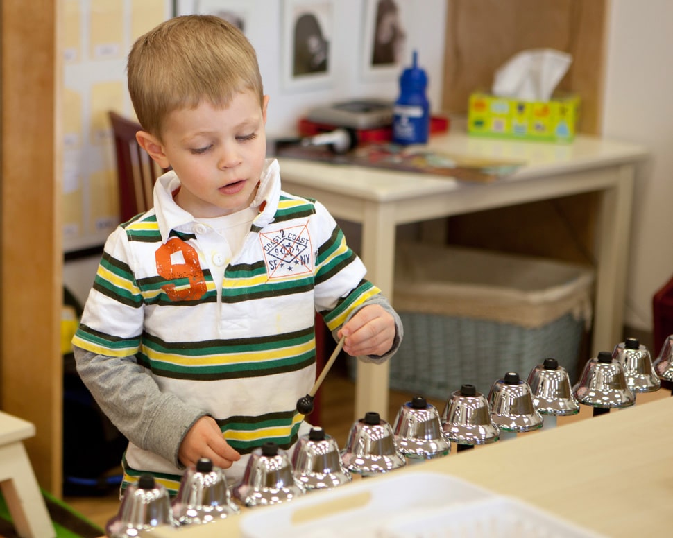 Child learning about sound with an instrument