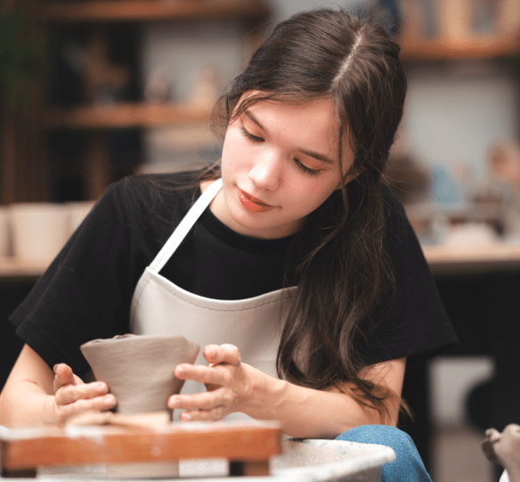 Student works on making a bowl in pottery class