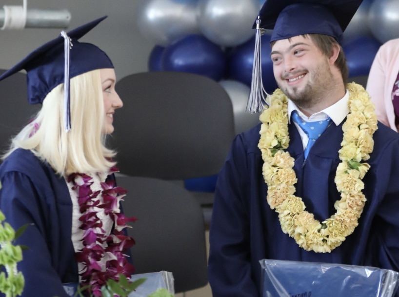 Two students chatting at their graduation ceremony