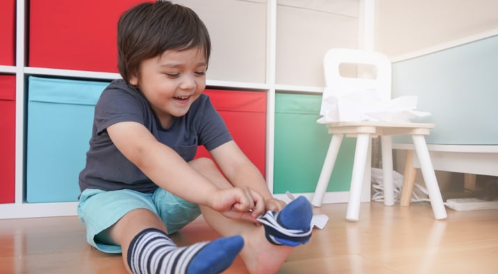 Toddler puts on a sock